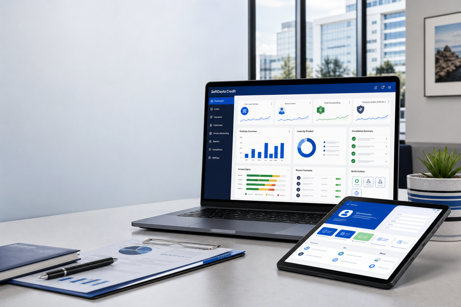 SoftDayta Credit loan management dashboard shown on a laptop and tablet